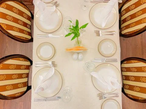 The dining table is covered with a white tablecloth, there are appliances on the Stock Photos