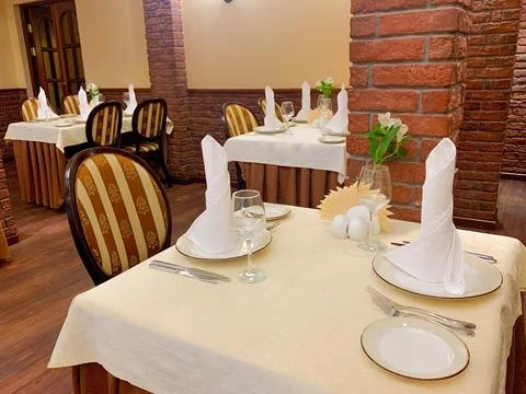 The dining table is covered with a white tablecloth, there are appliances on the Stock Photos