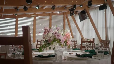 A dining table decorated with flowers in a bright and beautiful hall Stock Footage 184110375