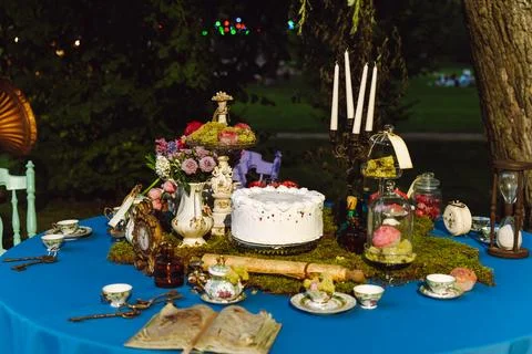 The dining table is decorated in the style of Alice in Wonderland. An open ol Stock Photos