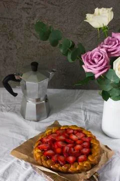 Dining table with flowers, coffee maker and strawberry pie, rustic style Stock Photos