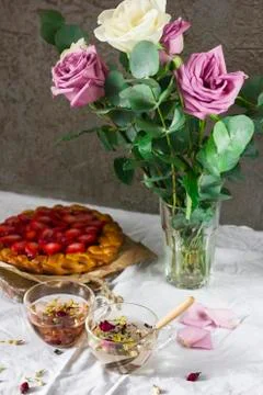 Dining table with flowers, herbal tea and strawberry pie, rustic style Stock Photos