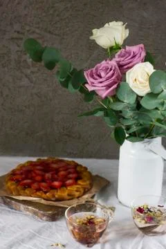 Dining table with flowers, tea and strawberry pie, rustic style Stock Photos