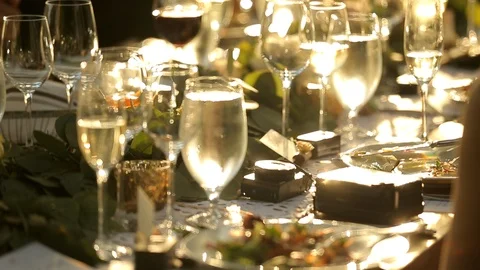 Dining table with full wine and champaign glasses in evening sun A Stock Footage 110878921