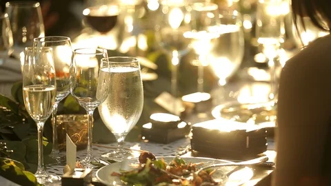 Dining table with full wine and champaign glasses in evening sun B Stock Footage 110879038