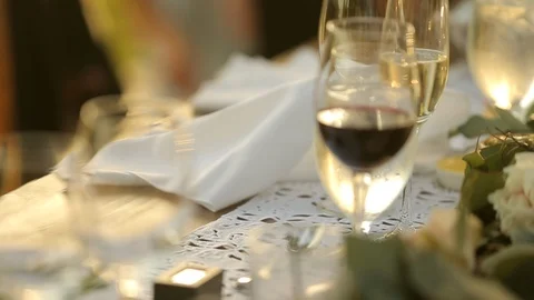 Dining table with full wine and champaign glasses in evening sun cu Stock Footage 110879039