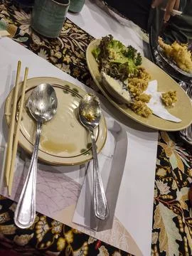 Dining table holds empty plates with spoons and chopsticks Stock Photos