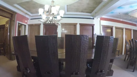 Dining table lined by high back chairs from behind view Stock-Footage 97226580