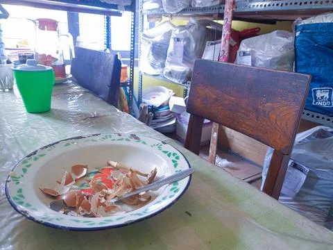 The dining table is in a mess. A messy dining table with used dishes and full Stock Photos