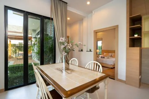 Dining table with pool view in luxury home Stock Photos