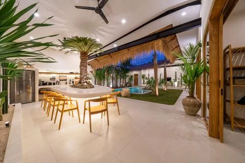 Dining table with pool view in luxury home Stock Photos