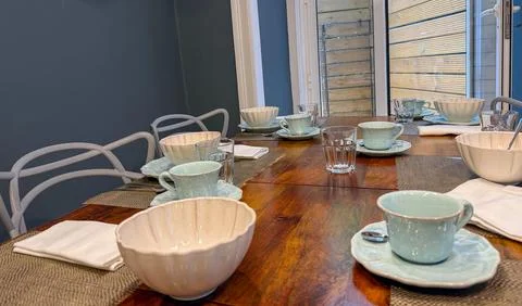 A dining table ready for a meal with plates and glasses, concept of food Stock-Fotos