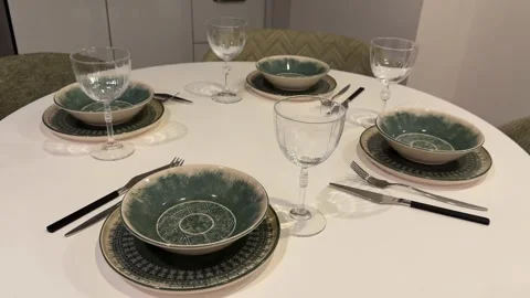 Dining table set with plates and glasses arranged for a meal in an elegant,.. 库存影片 331385495