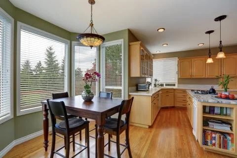 Dining table set with Tiffany style ceiling lamp. Open to kitchen room.  Stock Photos