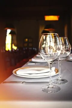 Dining table set with wine glasses by the window in a luxury restaurant Stock Photos