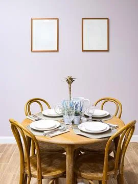 Dining table set with wooden chairs and white plates in a minimalist home i.. Stock Photos