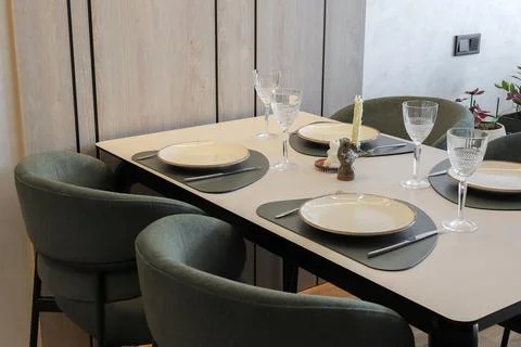 Dining table setting and green chairs 库存照片