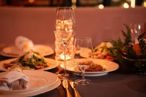 Dining table setup with dishes and glasses in a warm setting Stock Photos