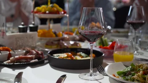 A dining table with snacks and drinks on the background of the guests. Stock Footage 248154939