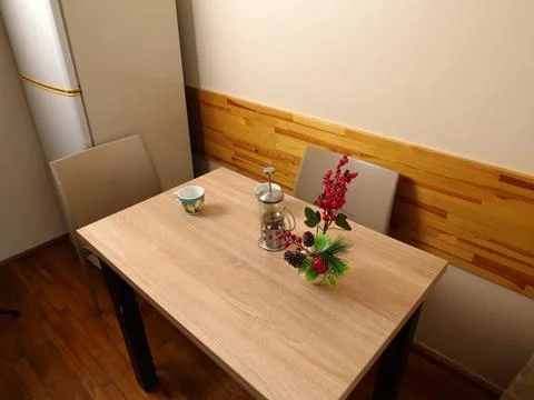 A dining table with tea ware and a festive arrangement of berries and evergre Stock Photos