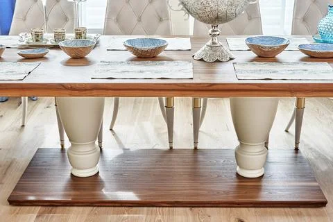 Dining table of walnut with festive setting and armchairs Stock Photos