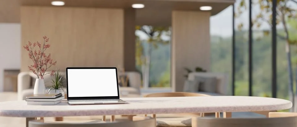 A dining table with a white-screen laptop mockup in a modern, luxury spacio.. Stock Illustration