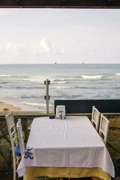Dining table with a white tablecloth on the background of the black sea. table Foto stock