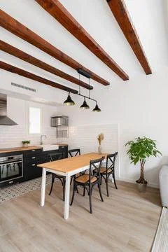 Dining table with wooden surface and chairs in kitchen Фото