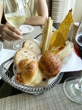 Dinner bread on table with wine and woman Stock Photos