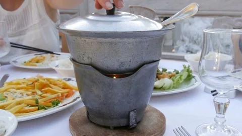 Dinner in a chinese restaurant. A hot pot is heated by a candle. 4K Stock Footage 80366871