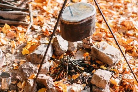 Dinner cooks in a large pot over an open fire. autumn forest Foto stock