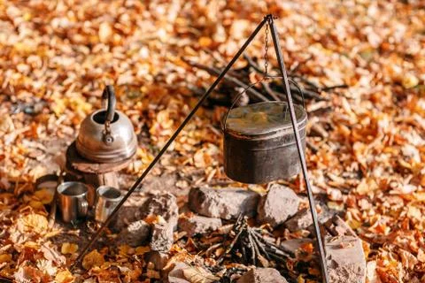 Dinner cooks in a large pot over an open fire. autumn forest Foto stock