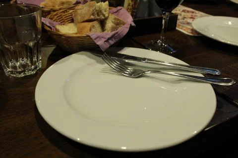 Dinner lunch in the restaurant cafe. An empty white plate and appliances fork Stock Photos