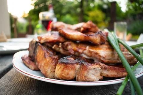 Dinner outdoors The appetizing steaks and red wine on the rustic table Stock Photos