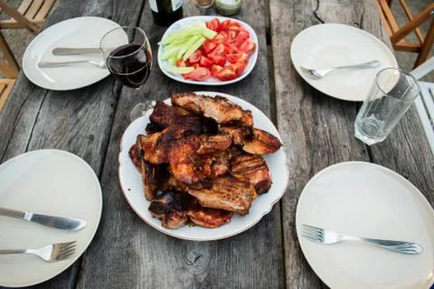 Dinner outdoors The appetizing steaks on the rustic table Stock Photos