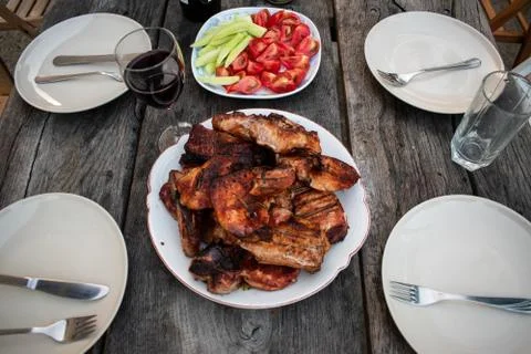 Dinner outdoors The appetizing steaks on the rustic table Stock Photos