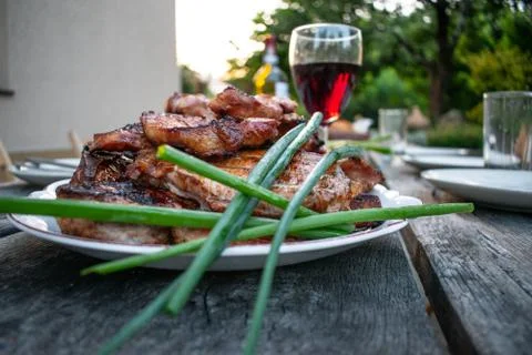 Dinner outdoors The appetizing steaks on the rustic table Stock Photos