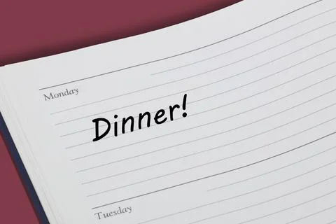 Dinner reminder note in black ink in a diary page Stock Photos