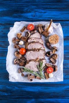 Dinner set of baked cold-boiled pork meat, fried mushrooms, baked garlic and  Foto stock