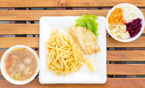 Dinner set, fish soup, fish and chips and cabbage salad Stock Photos