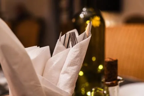 Dinner setting with elegant utensils and a bottle of wine ready at a restaurant Stock Photos