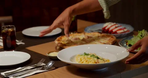 Dinner setting restaurant table with pasta dish, pizza, salad, drinks. Видео 311998362