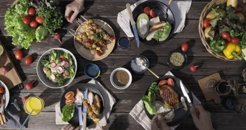 A dinner table with many grill steaks and vegetables salad with family Stock Footage 262403083