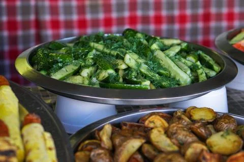 Dinner table with meat grill, roast new potatoes, vegetables, salads, sauces, Stock Photos
