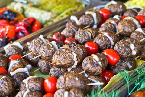 Dinner table with meat grill, roast new potatoes, vegetables, salads, sauces, Stock Photos