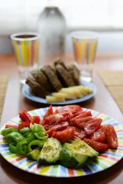 Dinner table with salad dish, bread and colorful water glass Stock Photos
