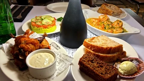Dinner table serving various seafood dishes and bread at a restaurant Stock Footage 333722346