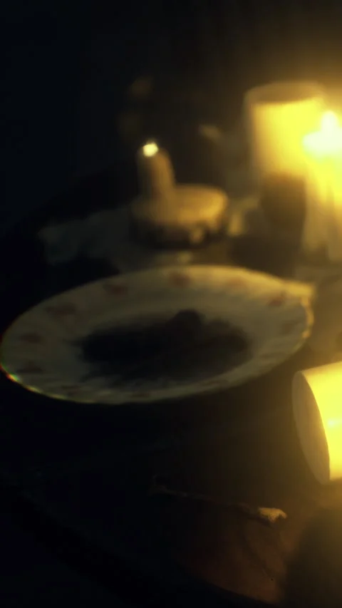 Dinner table set with candles and food in low light during evening hours Stock Footage 336177785