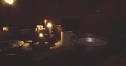 Dinner table set with candles and dishes in a dimly lit room setting Stock Illustration