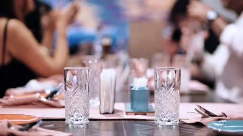 Dinner table setting with empty glasses, people enjoying a social gathering at a Stock Footage 327194982